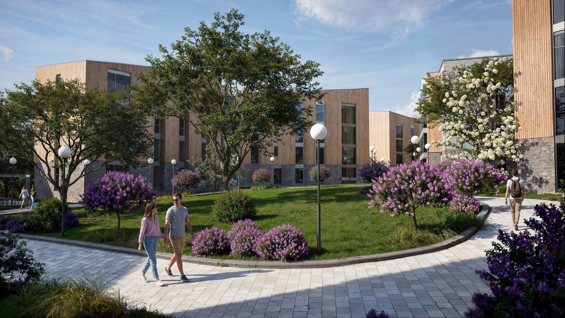 Landscaped courtyard garden at Halo Village with flowering shrubs, lawn and timber-clad accommodation